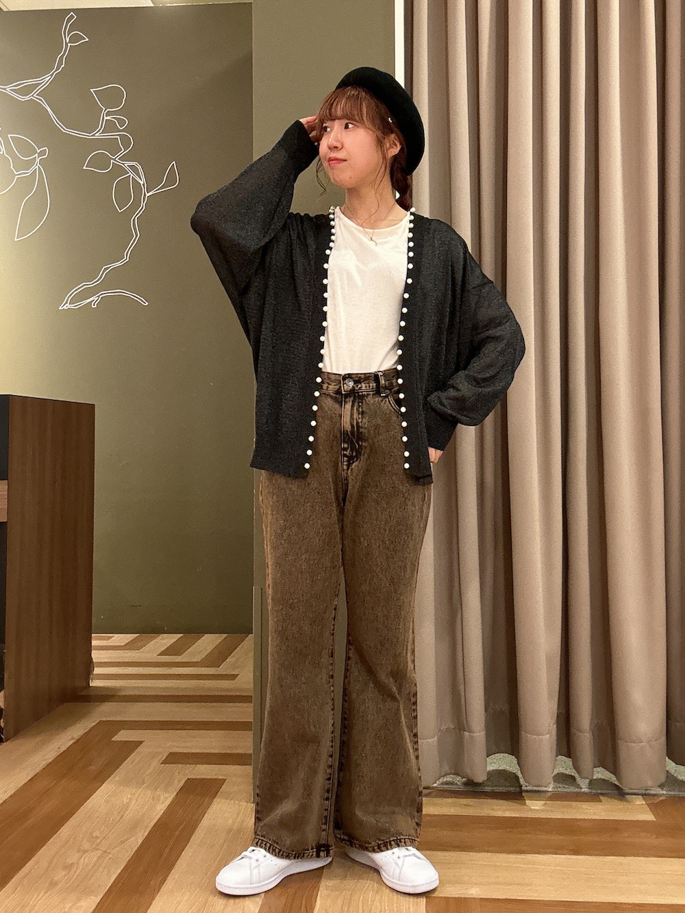 ブラック系のトップス、ブラック系のショルダーバッグ、ブラウン系のデニムパンツを着用したレディースの秋コーディネートの2枚目の写真