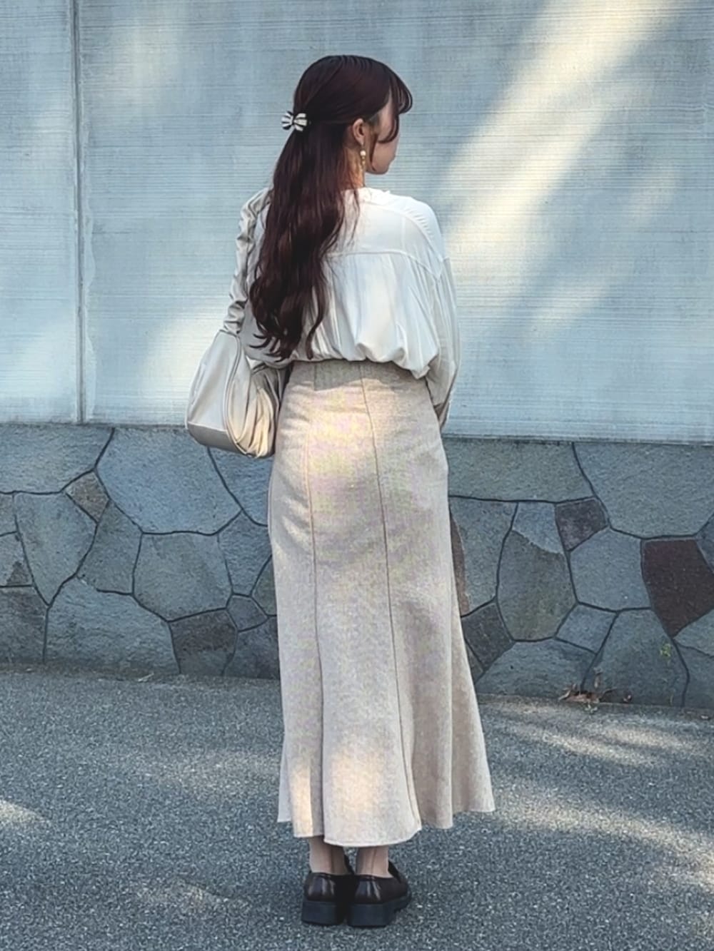 ベージュ系のセットアップ、ホワイト系のシャツ/ブラウス、ホワイト系のハンドバッグを着用したレディースの春コーディネートの2枚目の写真