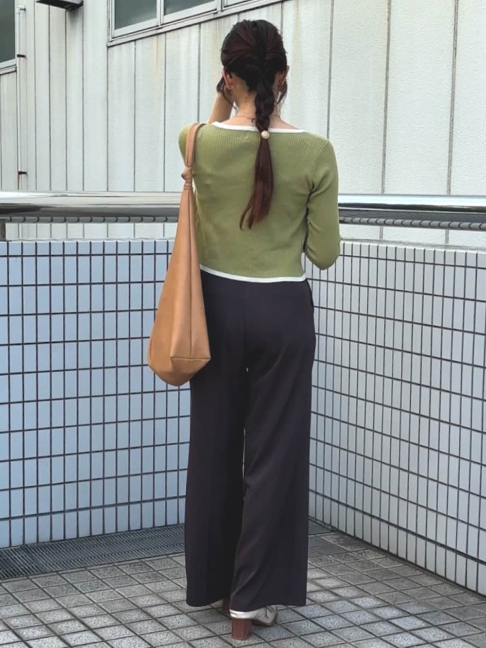 グリーン系のアンサンブル、ブラウン系のスラックス、ホワイト系のパンプスを着用したレディースの秋コーディネートの2枚目の写真