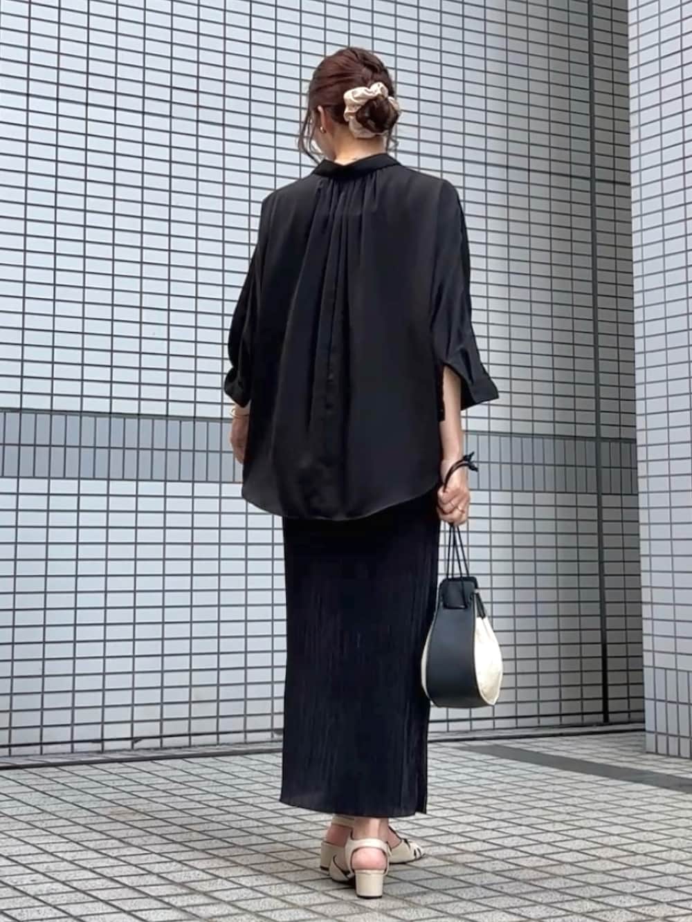 ホワイト系のサンダル、ブラック系のハンドバッグ、グリーン系のキャミソールを着用したレディースの夏コーディネートの2枚目の写真