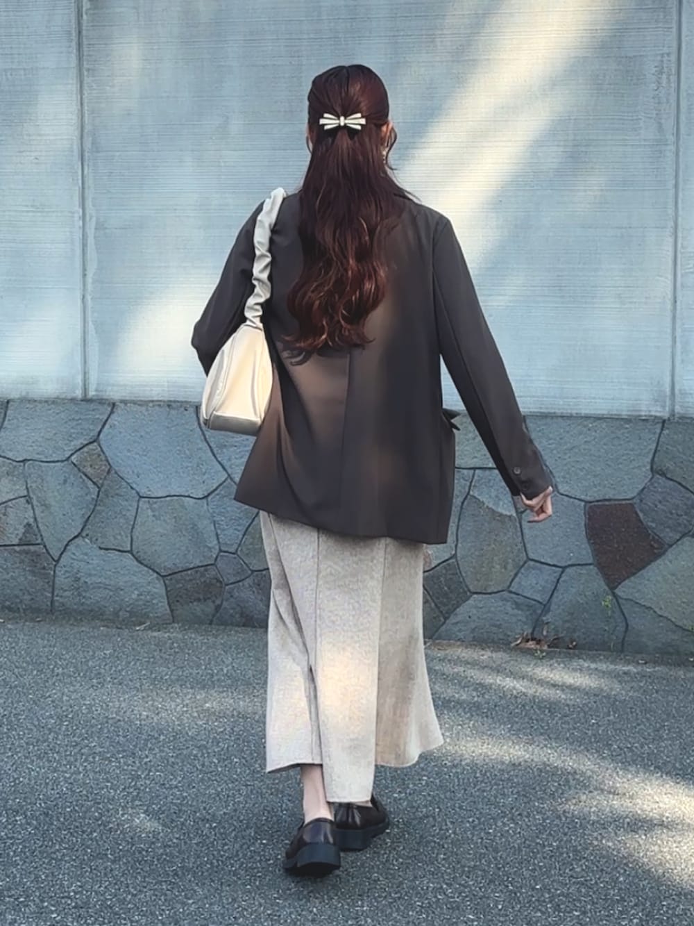 ベージュ系のセットアップ、ホワイト系のシャツ/ブラウス、ホワイト系のハンドバッグを着用したレディースの春コーディネートの3枚目の写真