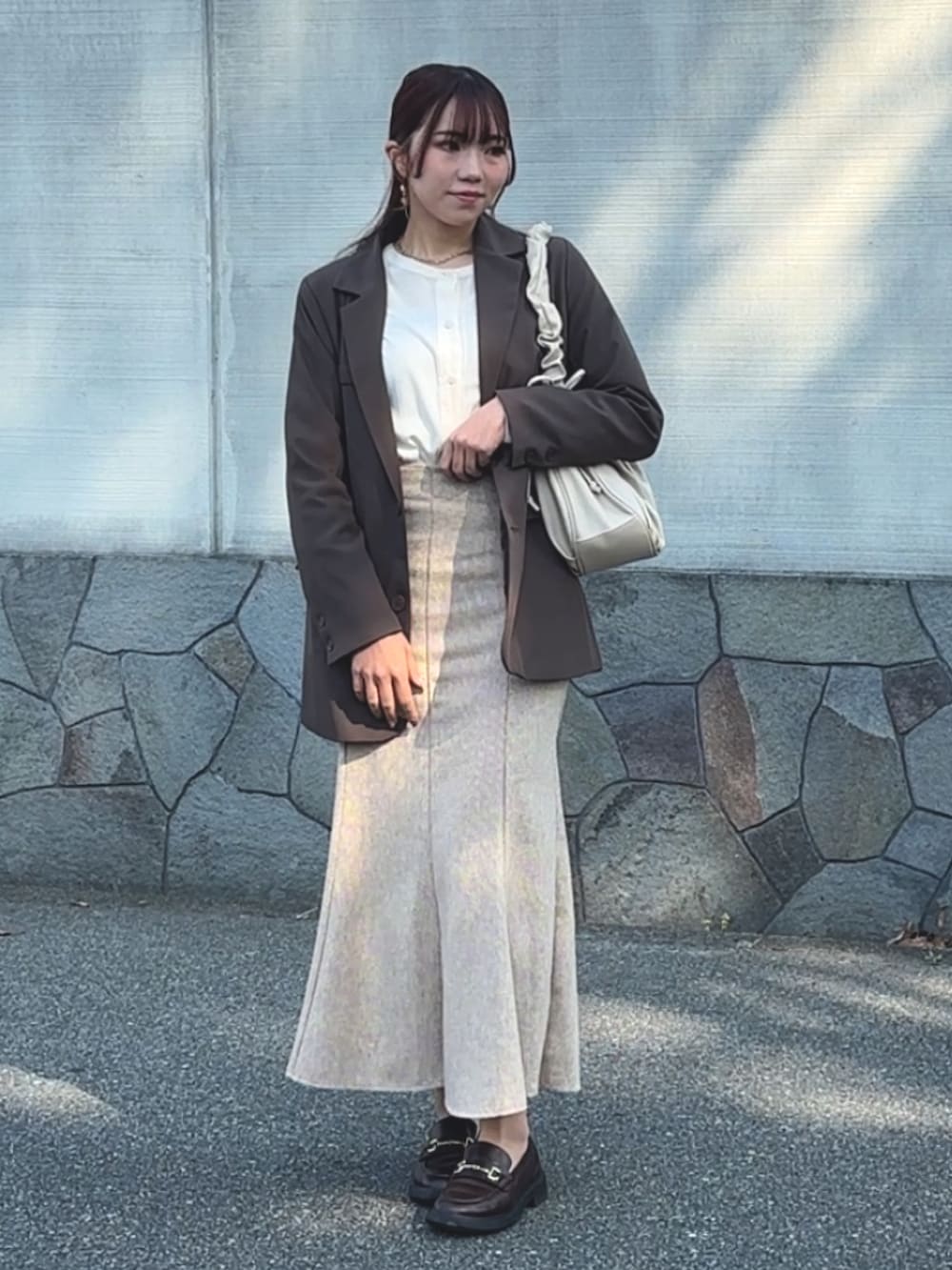 ベージュ系のセットアップ、ホワイト系のシャツ/ブラウス、ホワイト系のハンドバッグを着用したレディースの春コーディネートの4枚目の写真