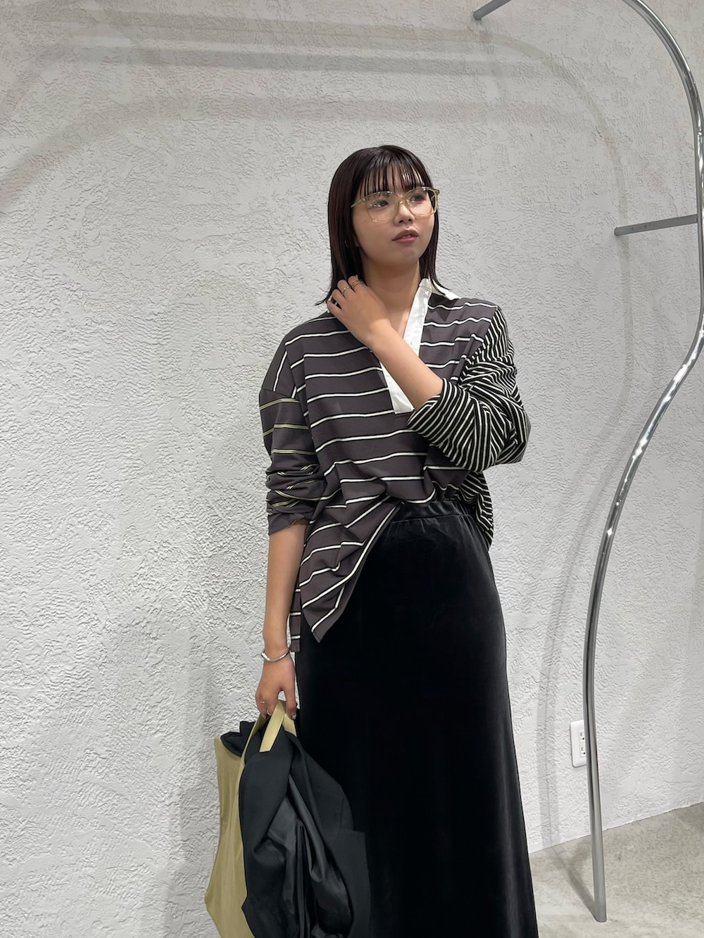 グレー系のスカート、ブラック系のTシャツ/カットソー、ブラック系のブーツを着用したレディースの秋コーディネートの4枚目の写真