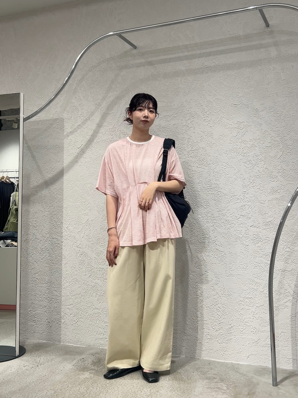 ピンク系のTシャツ/カットソー、ベージュ系のその他パンツ、ブラック系のバックパック/リュックを着用したレディースの夏コーディネートの4枚目の写真