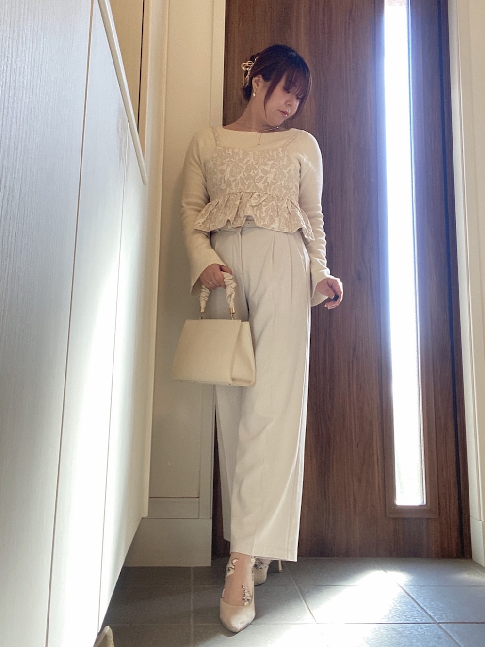 ベージュ系のハンドバッグ、ホワイト系のスラックス、ホワイト系のニット/セーターを着用したレディースの冬コーディネートの4枚目の写真