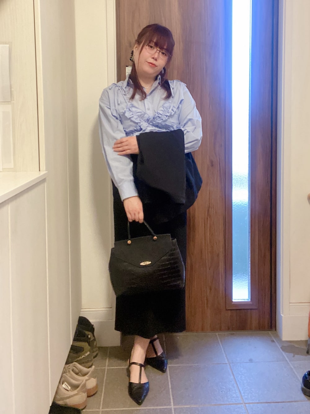 ブラック系のパンプス、ブラック系のハンドバッグ、ブルー系のキャミソールを着用したレディースの春コーディネートの3枚目の写真