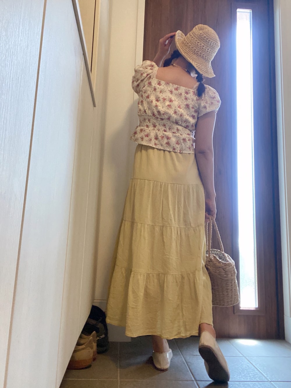 イエロー系のスカート、ベージュ系のかごバッグ、ホワイト系のバレエシューズを着用したレディースの春コーディネートの3枚目の写真