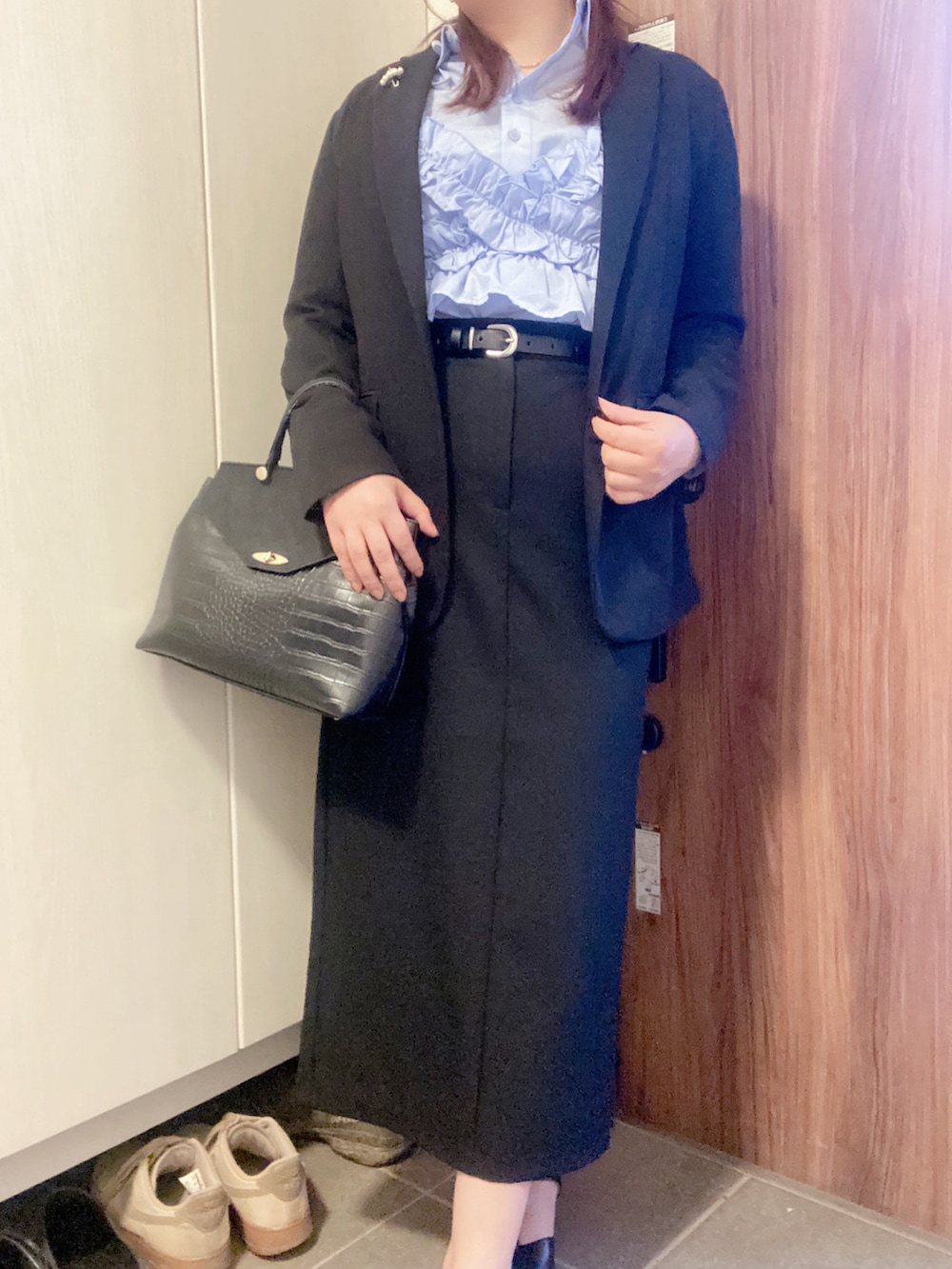 ブラック系のパンプス、ブラック系のハンドバッグ、ブルー系のキャミソールを着用したレディースの春コーディネートの4枚目の写真