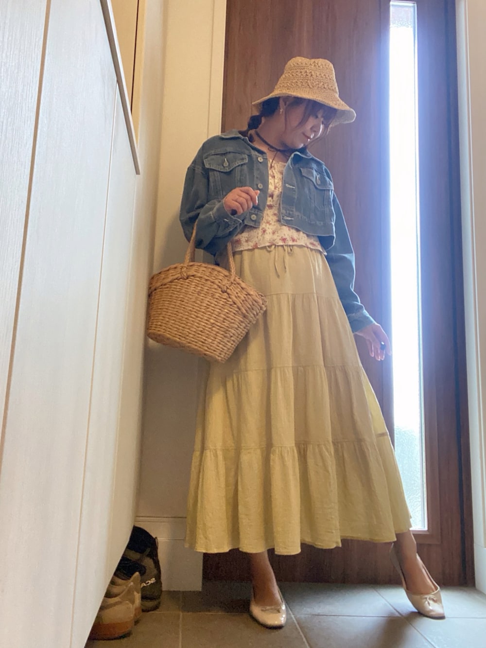 イエロー系のスカート、ベージュ系のかごバッグ、ホワイト系のバレエシューズを着用したレディースの春コーディネートの4枚目の写真