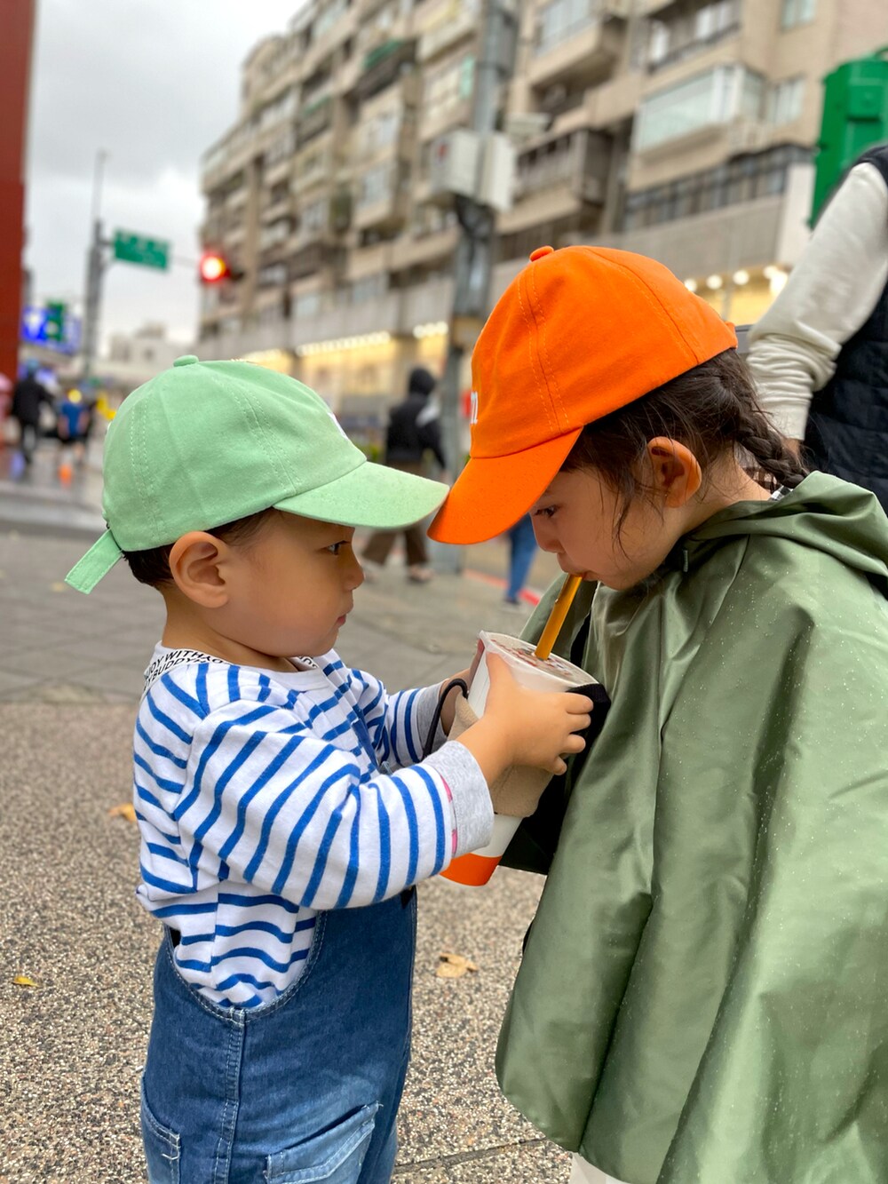 オレンジ系のキャップ、グリーン系のキャップを着用したレディースの春コーディネートの2枚目の写真