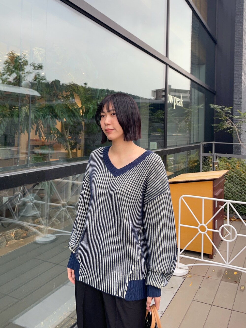 ブルー系のニット/セーター、ブラック系のその他パンツ、ブラック系のトートバッグを着用したレディースの冬コーディネートの3枚目の写真