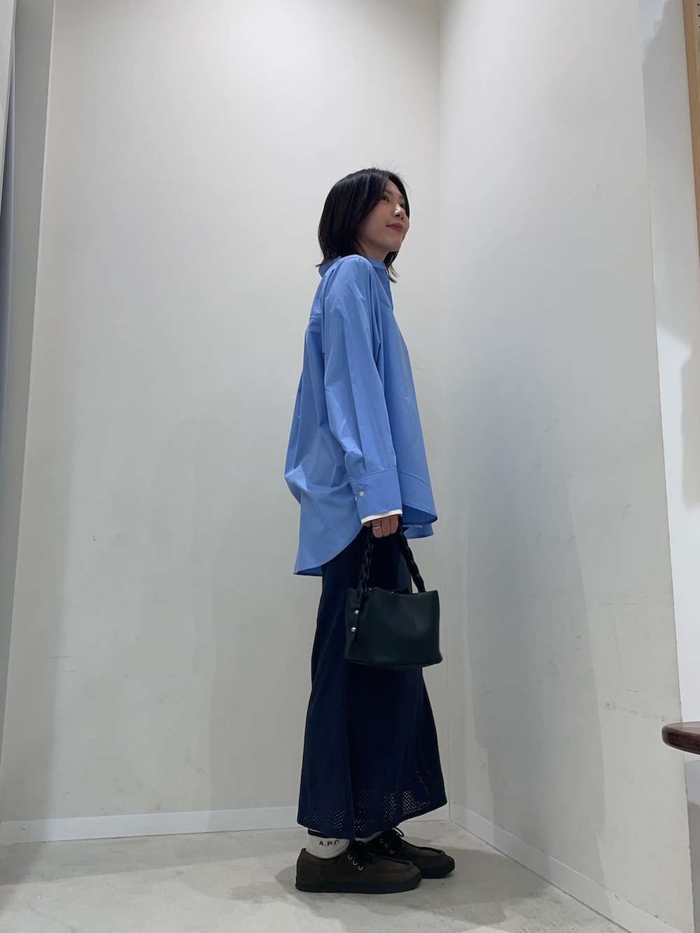 ブルー系のシャツ/ブラウス、ブルー系のスカート、ブラック系のショルダーバッグを着用したレディースの冬コーディネートの3枚目の写真