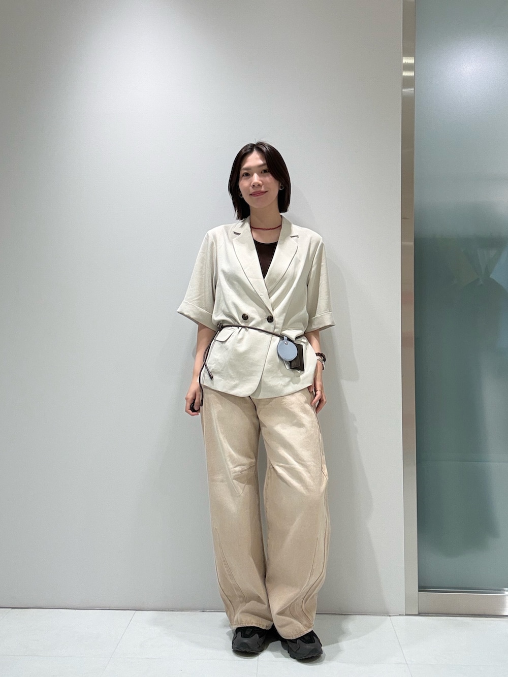 ベージュ系のその他アウター、ブラウン系のキャミソール、ベージュ系のデニムパンツを着用したレディースの春コーディネートの3枚目の写真