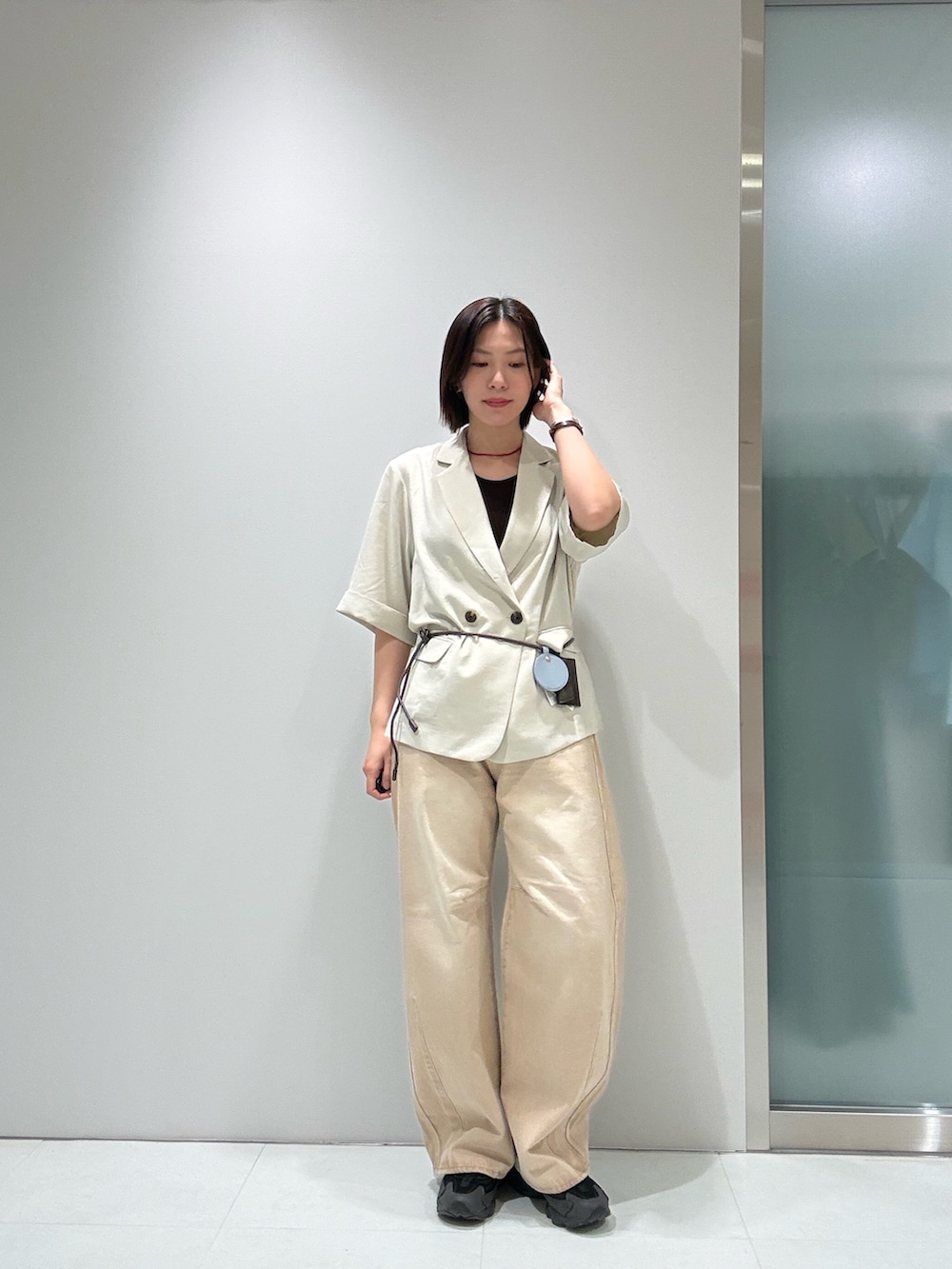 ベージュ系のその他アウター、ブラウン系のキャミソール、ベージュ系のデニムパンツを着用したレディースの春コーディネートの2枚目の写真