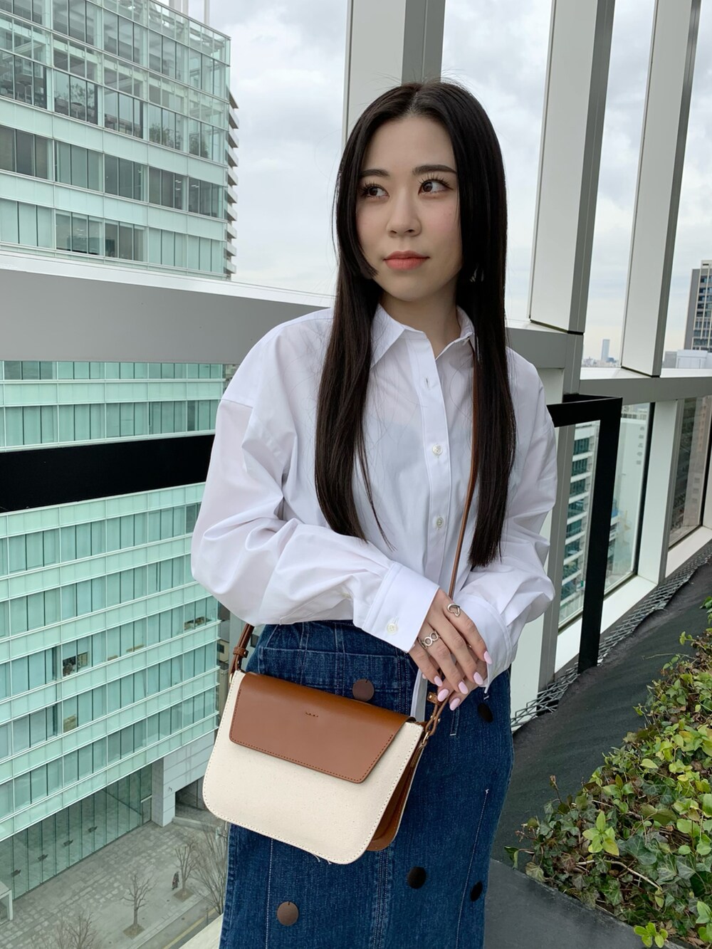 ブラウン系のショルダーバッグを着用したレディースの冬コーディネートの2枚目の写真