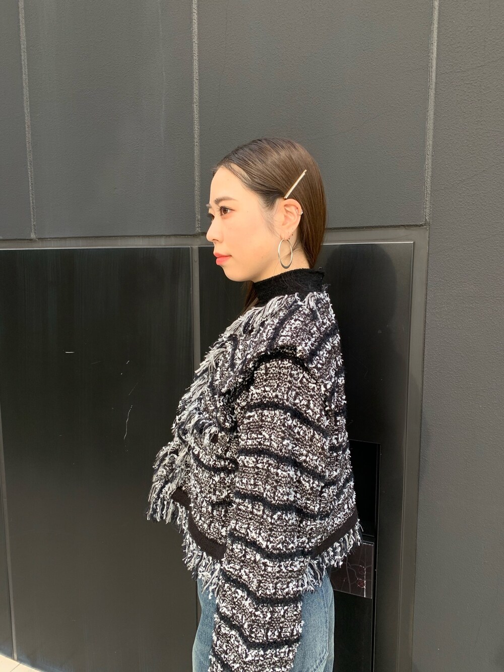 ブルー系のデニムパンツ、シルバー系のブーツ、イエロー系のハンドバッグを着用したレディースの秋コーディネートの3枚目の写真