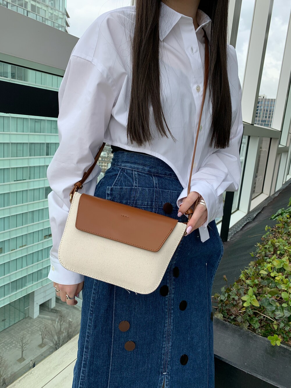 ブラウン系のショルダーバッグを着用したレディースの冬コーディネートの3枚目の写真