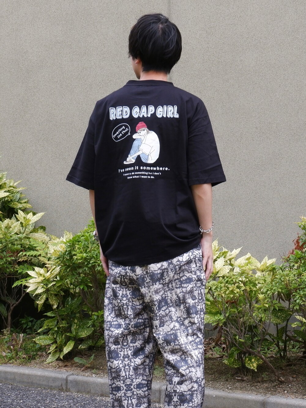 ブラック系のTシャツ/カットソー、ホワイト系のスラックス、ブラック系のサンダルを着用したメンズの夏コーディネートの2枚目の写真