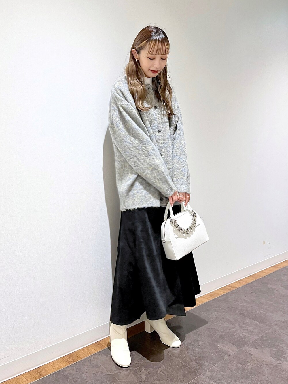 ベージュ系のニット/セーター、ホワイト系のニット/セーター、ブラック系のスカートを着用したレディースの冬コーディネートの2枚目の写真