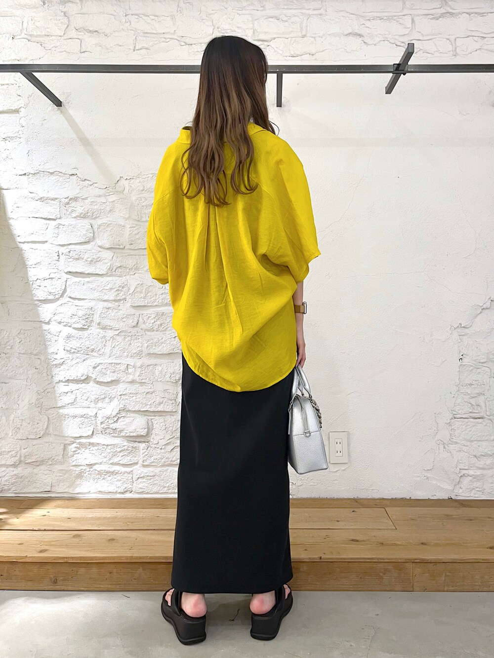 イエロー系のシャツ/ブラウス、ブラック系のタンクトップ、ブラック系のスカートを着用したレディースの夏コーディネートの3枚目の写真