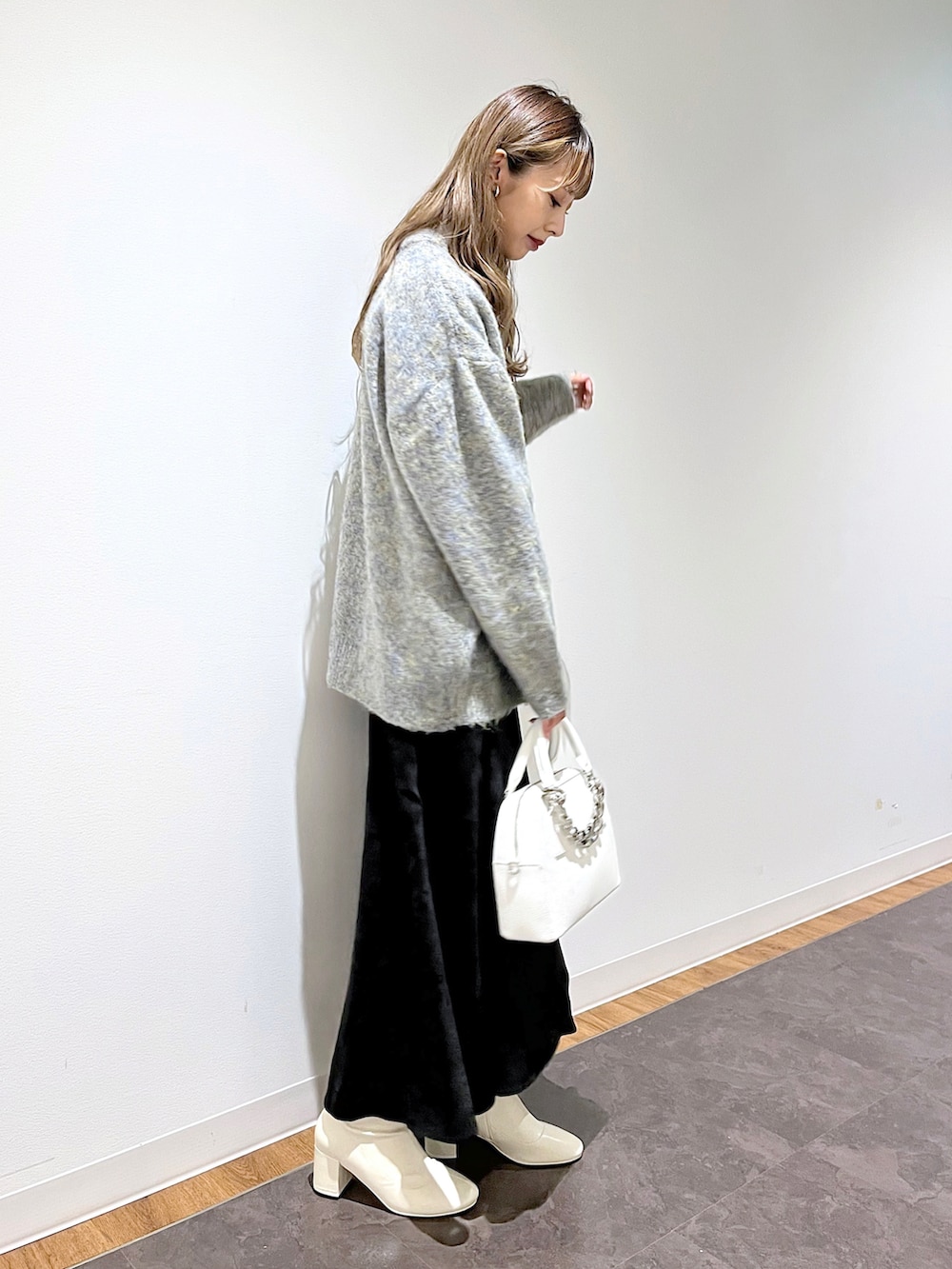 ベージュ系のニット/セーター、ホワイト系のニット/セーター、ブラック系のスカートを着用したレディースの冬コーディネートの3枚目の写真