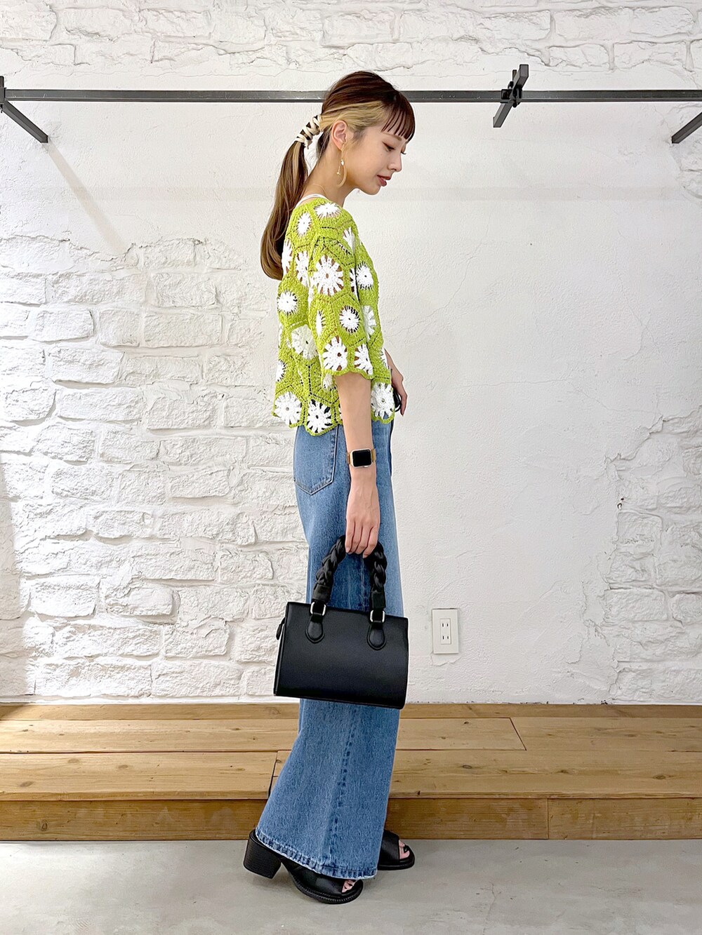 グリーン系のカーディガン/ボレロ、ホワイト系のキャミソール、ブルー系のデニムパンツを着用したレディースの夏コーディネートの3枚目の写真
