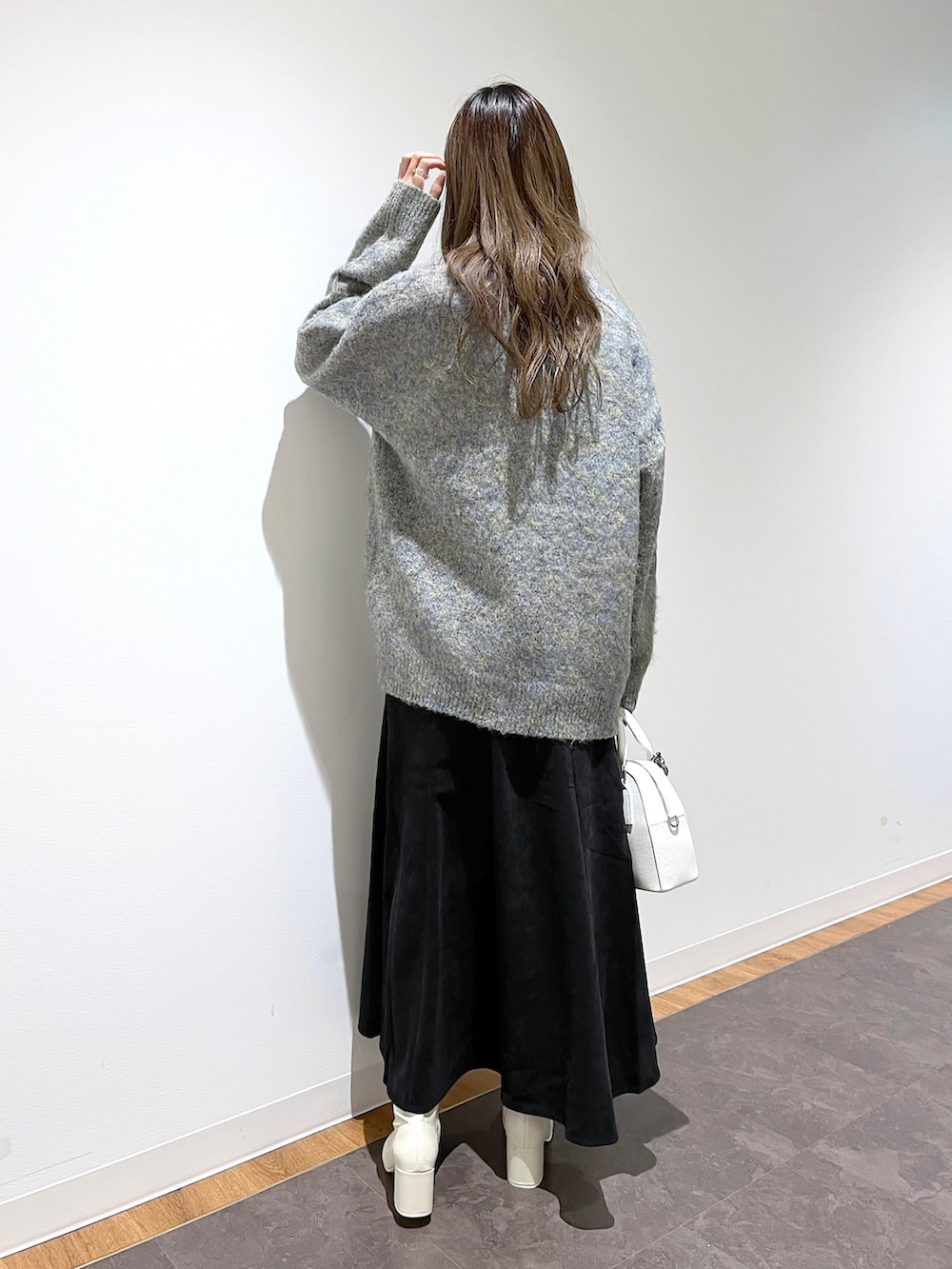 ベージュ系のニット/セーター、ホワイト系のニット/セーター、ブラック系のスカートを着用したレディースの冬コーディネートの4枚目の写真