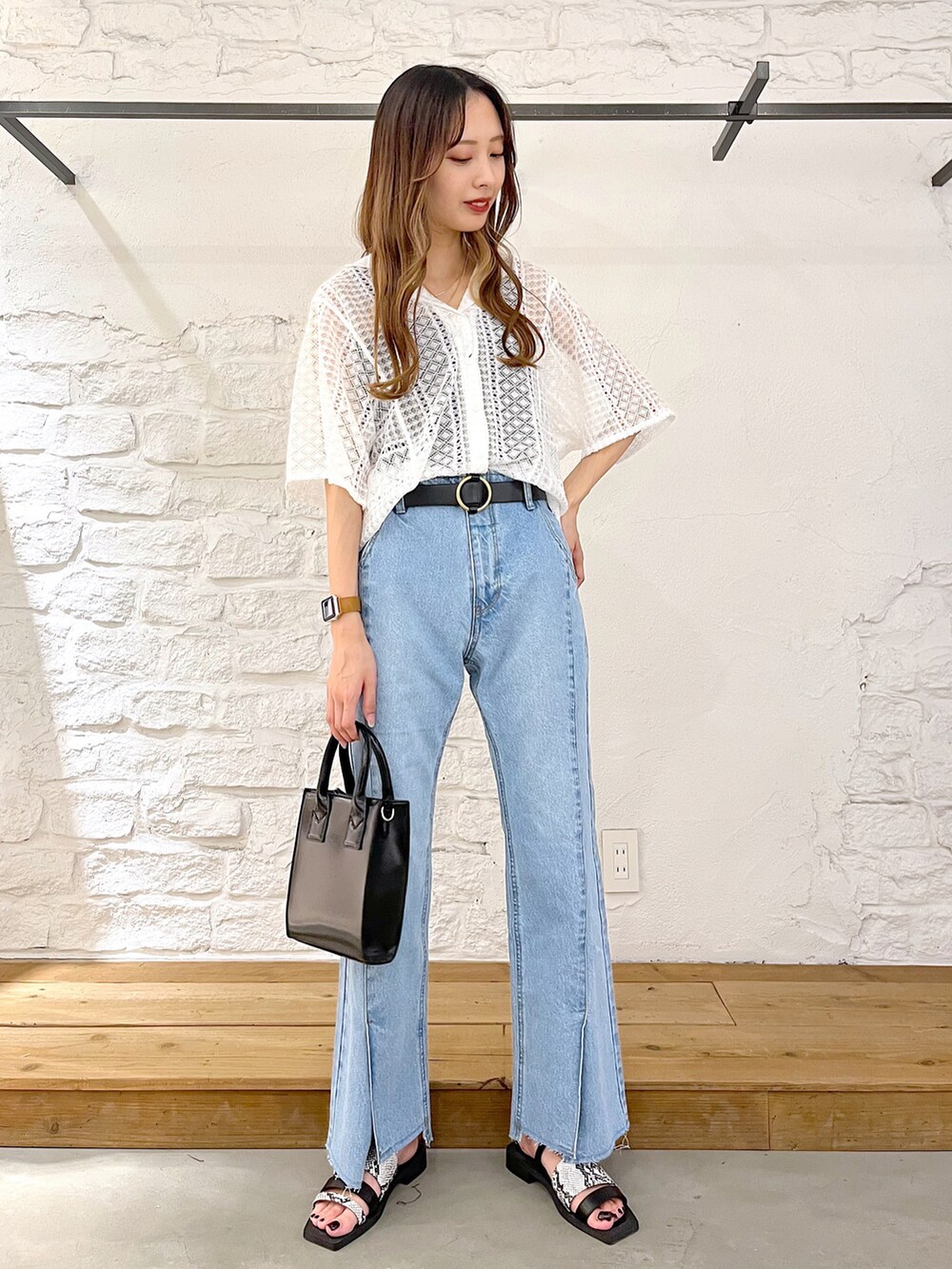 ホワイト系のシャツ/ブラウス、ブルー系のデニムパンツ、ブラック系のショルダーバッグを着用したレディースの夏コーディネートの2枚目の写真