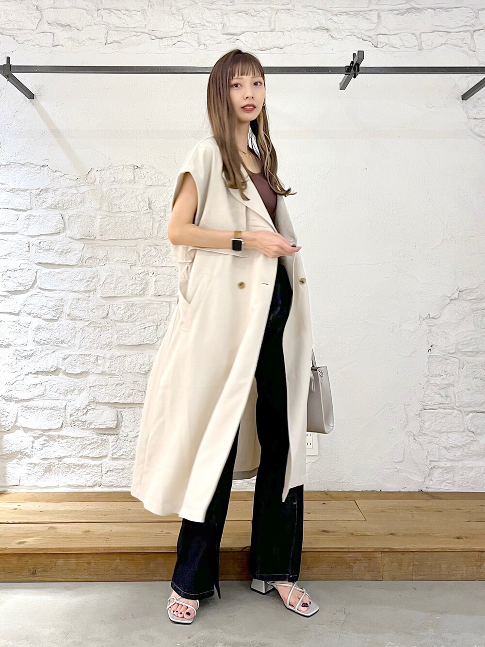 ベージュ系のその他アウター、ブルー系のデニムパンツ、シルバー系のショルダーバッグを着用したレディースの夏コーディネートの2枚目の写真