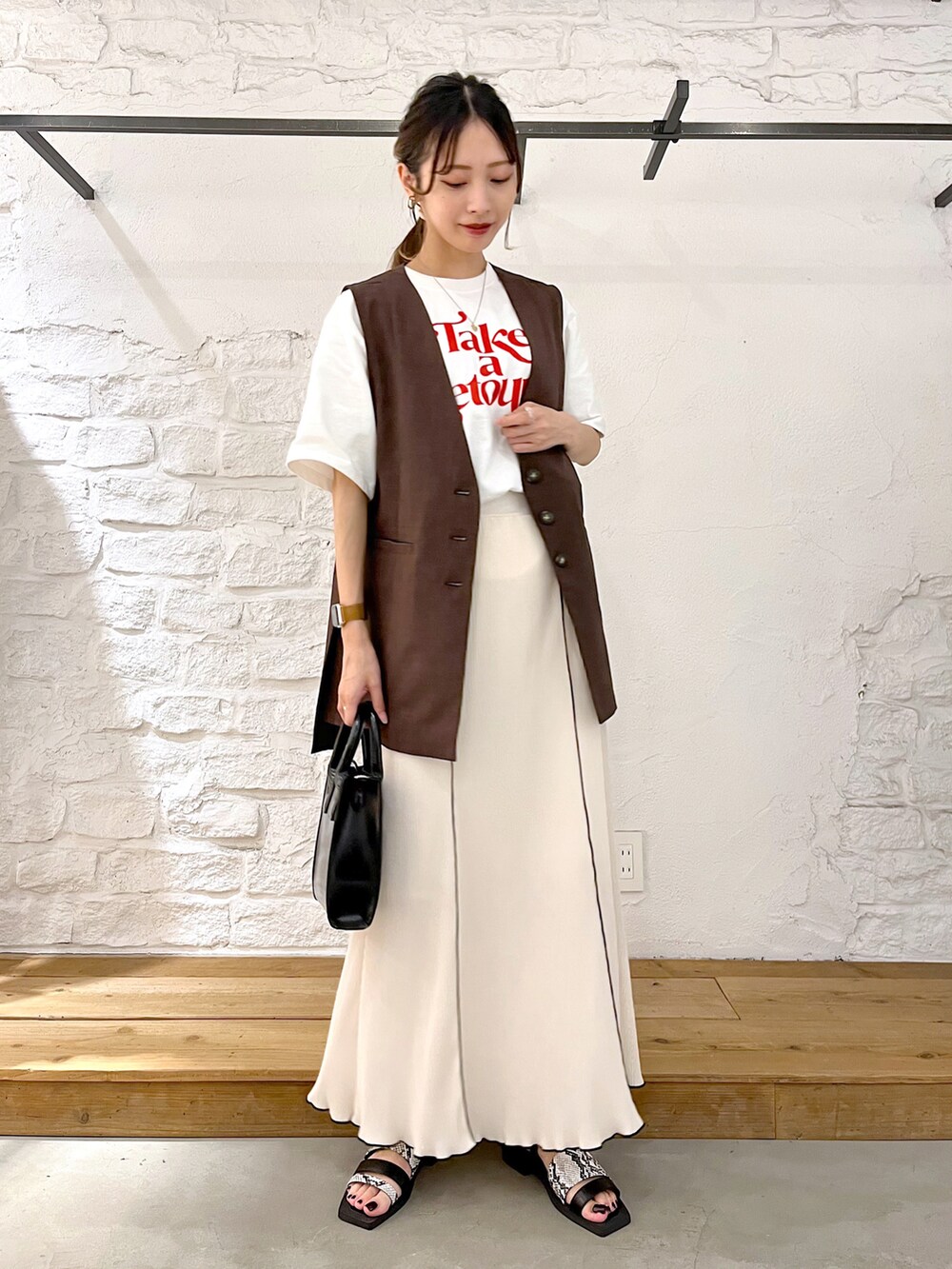 ホワイト系のTシャツ/カットソー、ブラウン系のその他アウター、ホワイト系のスカートを着用したレディースの夏コーディネートの2枚目の写真