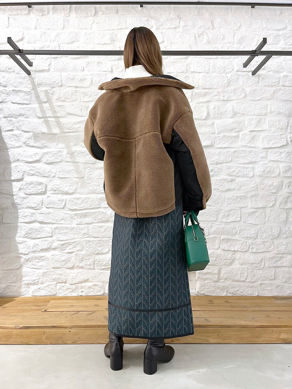 ブラウン系のブルゾン、ホワイト系のニット/セーター、グリーン系のショルダーバッグを着用したレディースの冬コーディネートの4枚目の写真