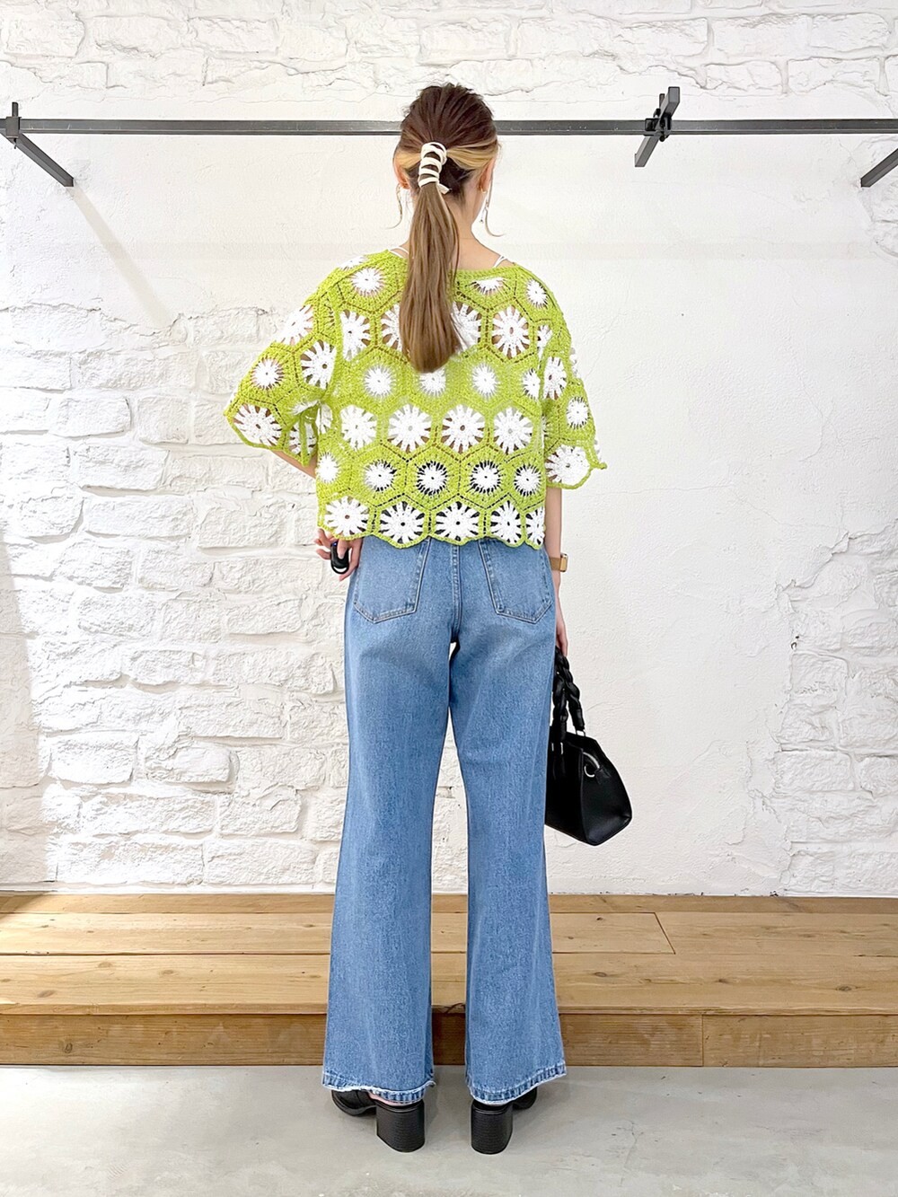 グリーン系のカーディガン/ボレロ、ホワイト系のキャミソール、ブルー系のデニムパンツを着用したレディースの夏コーディネートの4枚目の写真