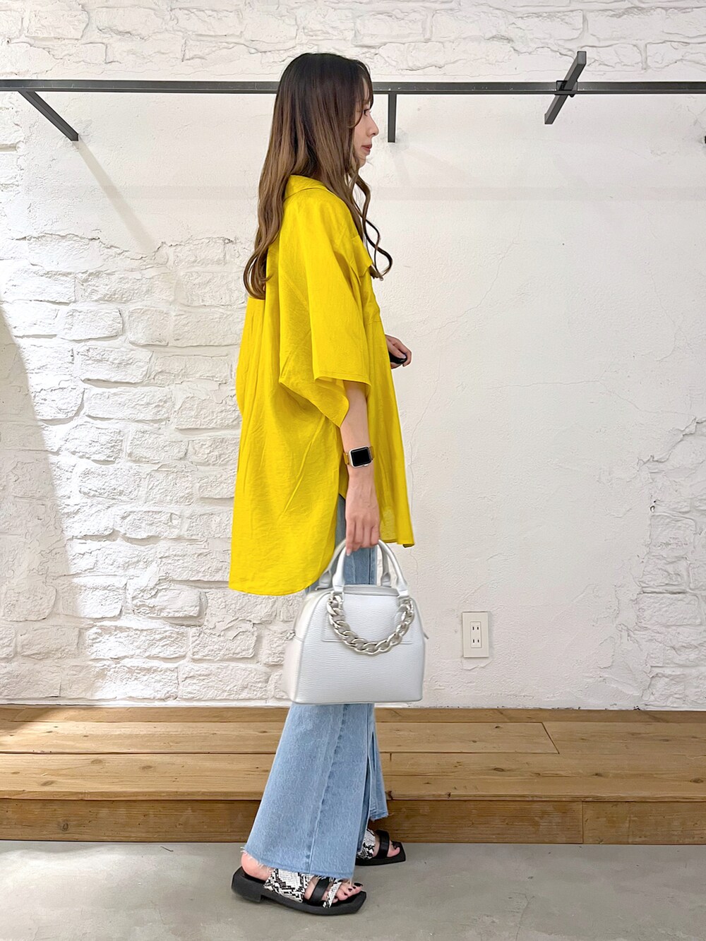 イエロー系のシャツ/ブラウス、ブラック系のタンクトップ、シルバー系のショルダーバッグを着用したレディースの夏コーディネートの3枚目の写真