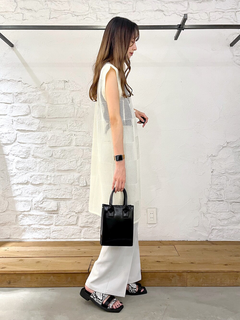 ホワイト系のカーディガン/ボレロ、ブラック系のショルダーバッグ、ベージュ系のスラックスを着用したレディースの夏コーディネートの3枚目の写真