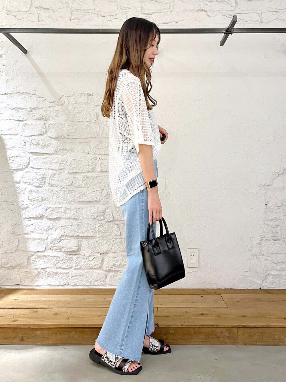 ホワイト系のシャツ/ブラウス、ブルー系のデニムパンツ、ブラック系のショルダーバッグを着用したレディースの夏コーディネートの3枚目の写真