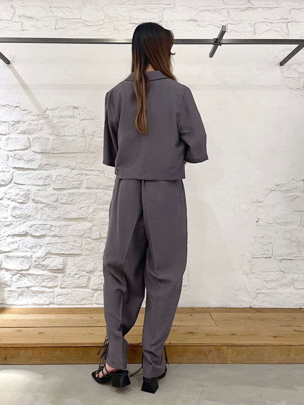 グレー系のテーラードジャケット、ホワイト系のタンクトップ、グレー系のスラックスを着用したレディースの夏コーディネートの4枚目の写真