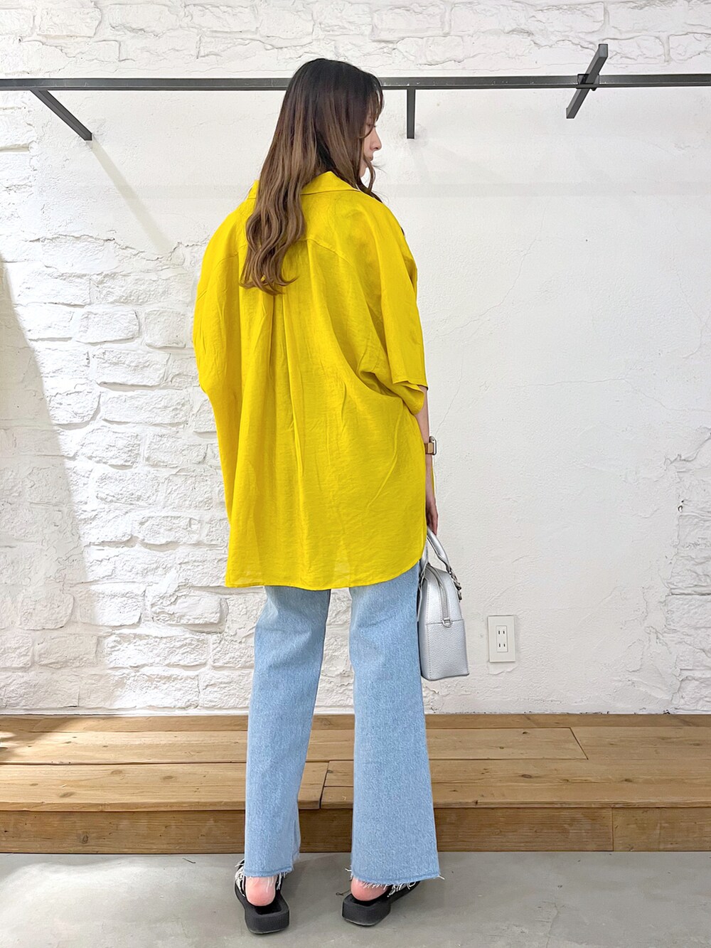 イエロー系のシャツ/ブラウス、ブラック系のタンクトップ、シルバー系のショルダーバッグを着用したレディースの夏コーディネートの4枚目の写真