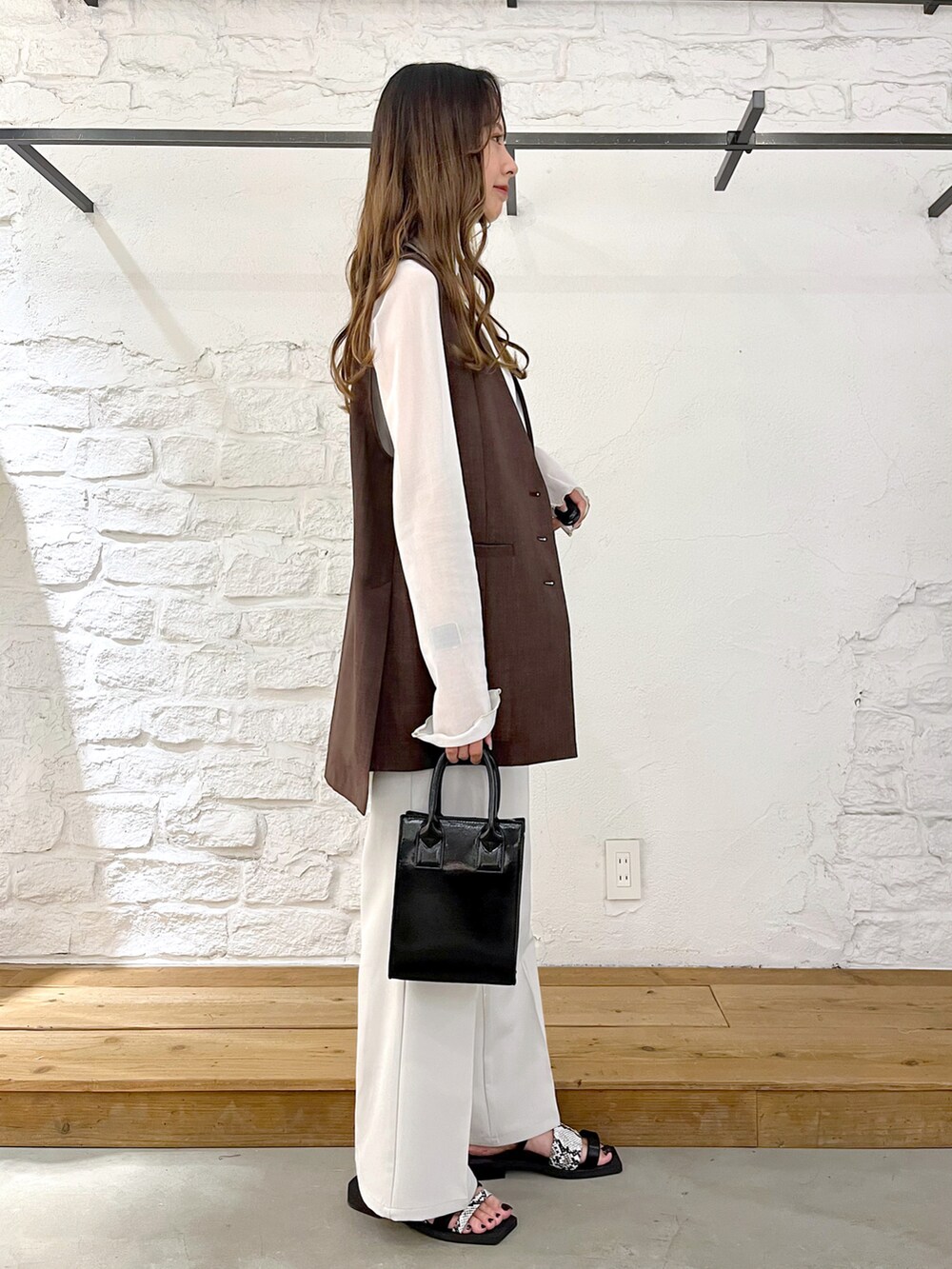 ブラウン系のその他アウター、ホワイト系のTシャツ/カットソー、ブラック系のショルダーバッグを着用したレディースの夏コーディネートの3枚目の写真