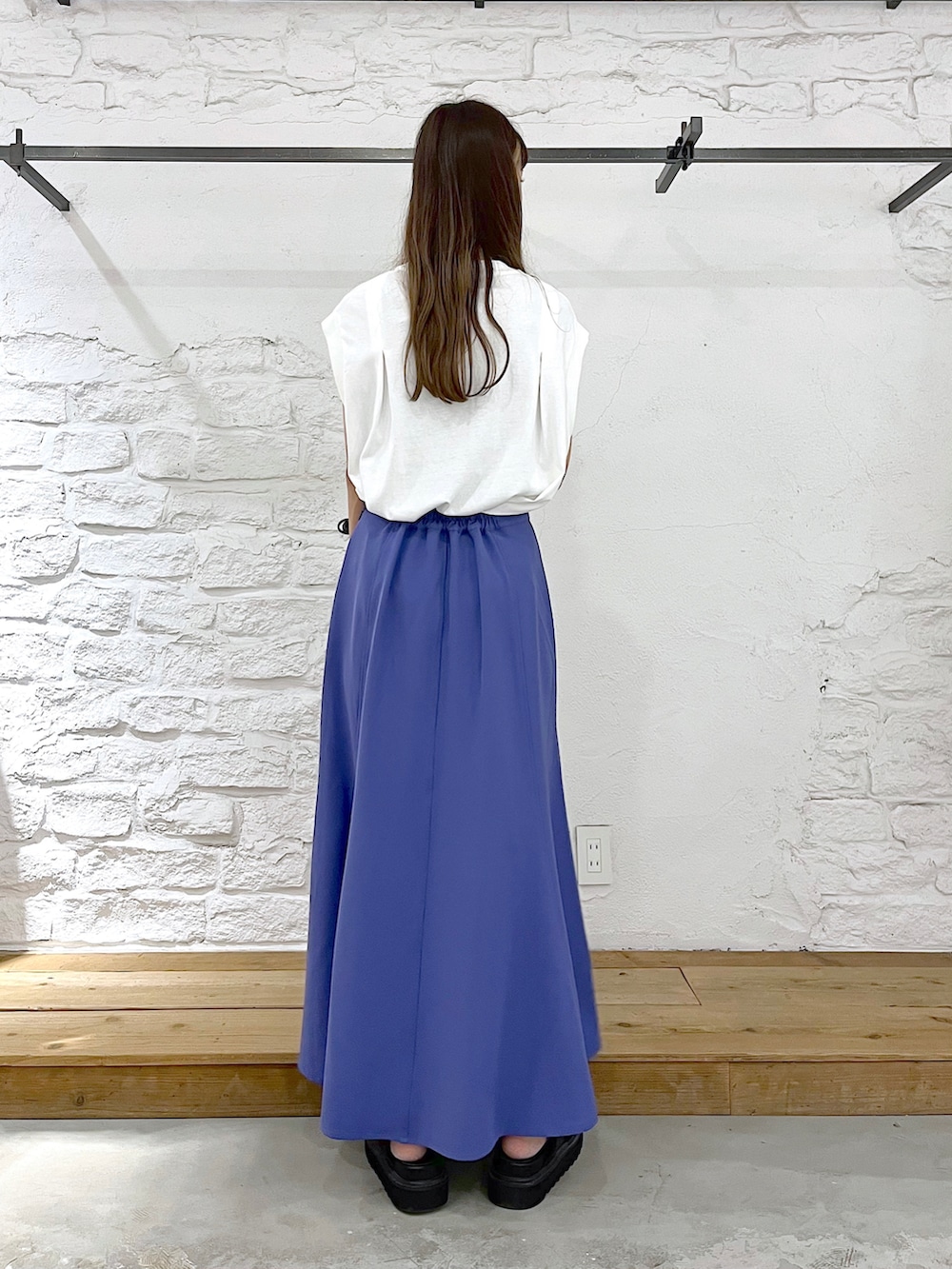 ホワイト系のTシャツ/カットソー、ブルー系のスカート、ブラック系のショルダーバッグを着用したレディースの夏コーディネートの4枚目の写真