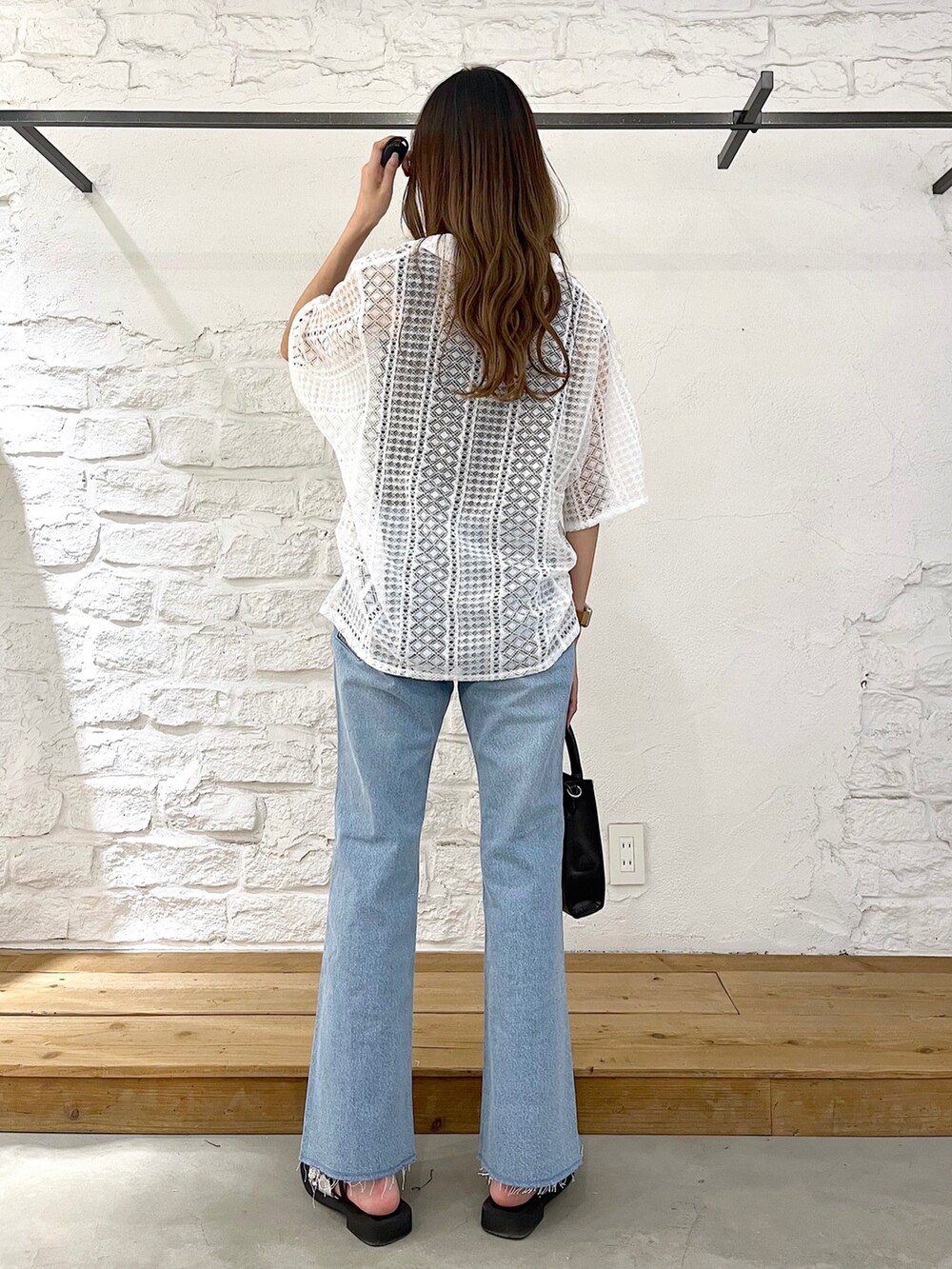 ホワイト系のシャツ/ブラウス、ブルー系のデニムパンツ、ブラック系のショルダーバッグを着用したレディースの夏コーディネートの4枚目の写真