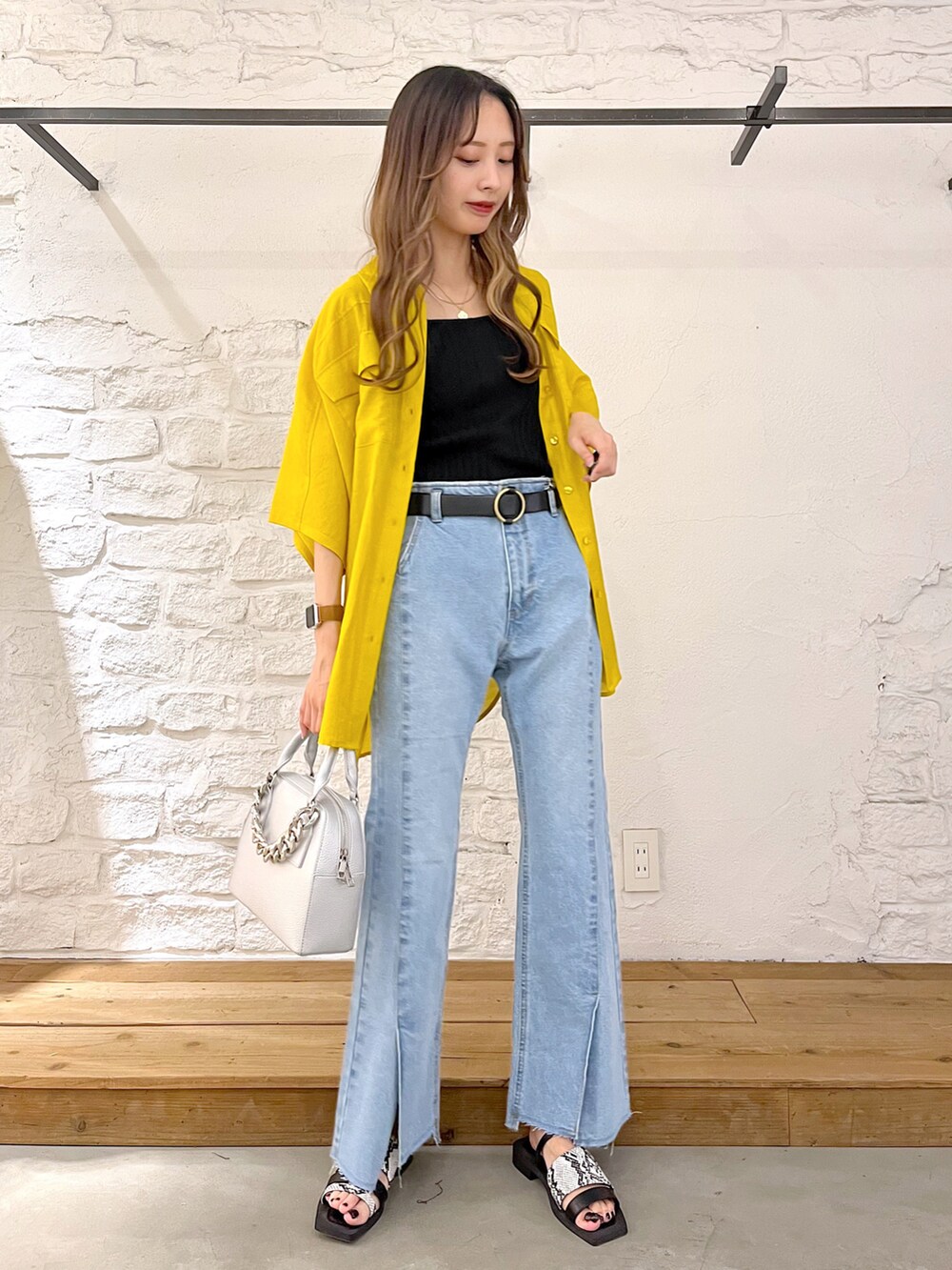 イエロー系のシャツ/ブラウス、ブラック系のタンクトップ、シルバー系のショルダーバッグを着用したレディースの夏コーディネートの2枚目の写真