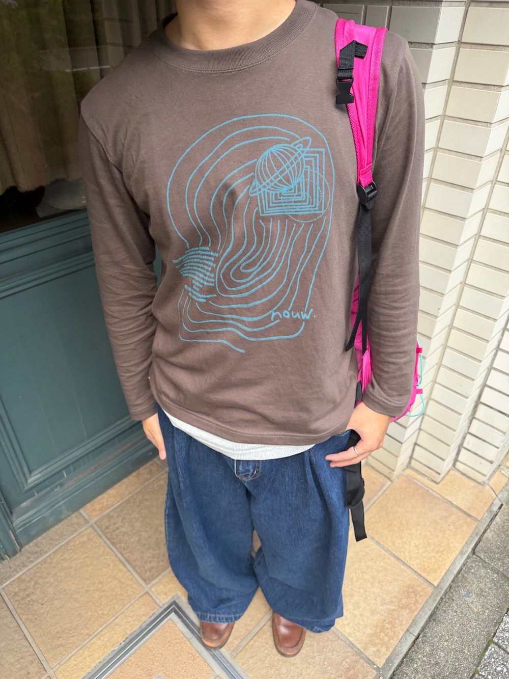 ブラウン系のTシャツ/カットソー、ブルー系のデニムパンツ、ブラウン系のブーツを着用したメンズの秋コーディネートの2枚目の写真
