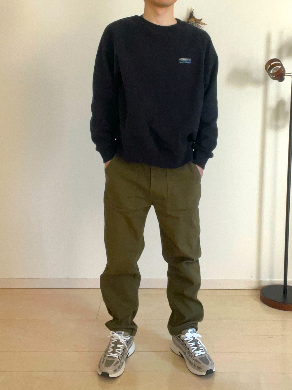 ブラウン系のスニーカー、ブラック系のブルゾン、ブラウン系のショルダーバッグを着用したメンズの冬コーディネートの2枚目の写真