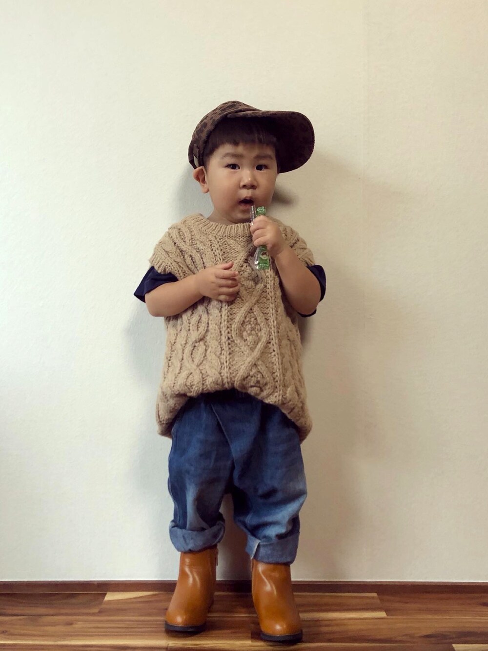 ベージュ系のベスト、ブルー系のその他パンツ、イエロー系のブーツを着用したキッズの秋コーディネートの2枚目の写真