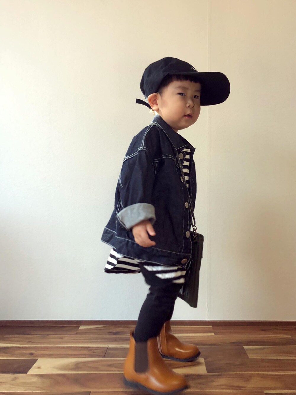 ブルー系のデニムジャケット、ブラック系のTシャツ/カットソー、グリーン系のバッグを着用したキッズの秋コーディネートの2枚目の写真