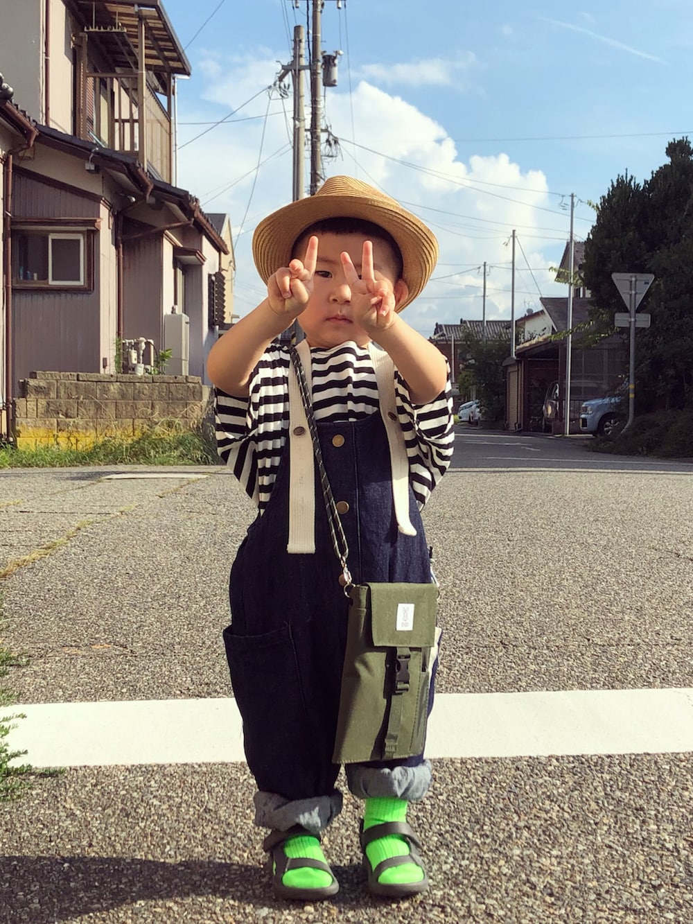 ブラック系のTシャツ/カットソー、ブルー系のサロペット/オーバーオール、グリーン系のバッグを着用したキッズの夏コーディネートの2枚目の写真