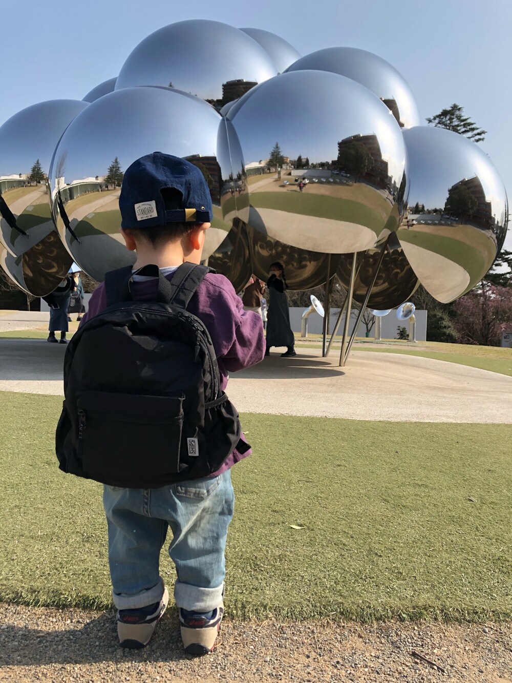 パープル系のTシャツ/カットソー、ブルー系のデニムパンツ、ブラック系のバックパック/リュックを着用したキッズの春コーディネートの3枚目の写真