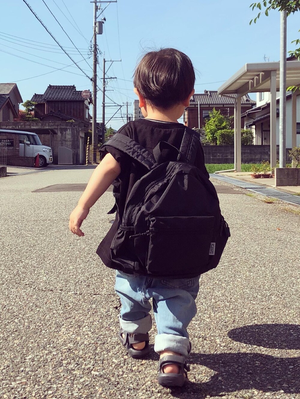 ブラック系のTシャツ/カットソー、ブルー系のデニムパンツ、グレー系のサンダルを着用したキッズの夏コーディネートの3枚目の写真