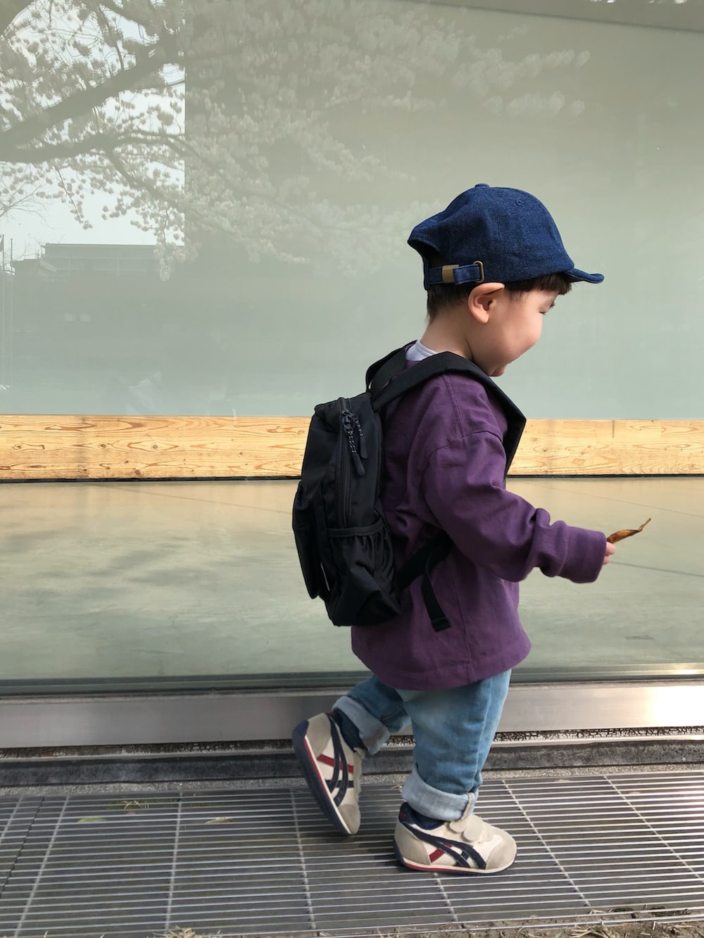 パープル系のTシャツ/カットソー、ブルー系のデニムパンツ、ブラック系のバックパック/リュックを着用したキッズの春コーディネートの2枚目の写真