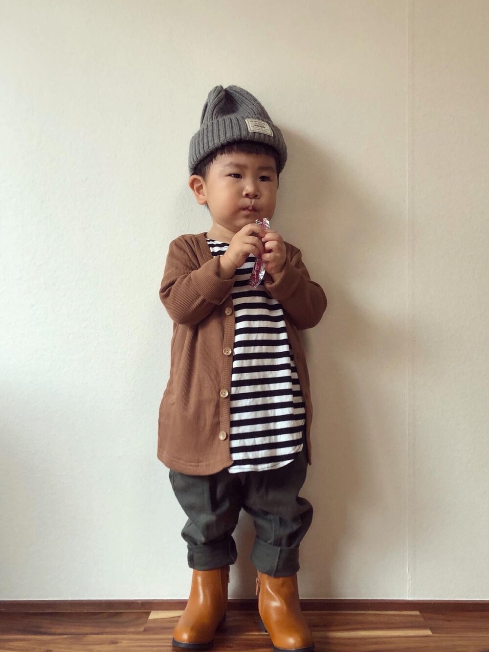 ブラウン系のカーディガン/ボレロ、ブラック系のTシャツ/カットソー、グリーン系のその他パンツを着用したキッズの秋コーディネートの4枚目の写真